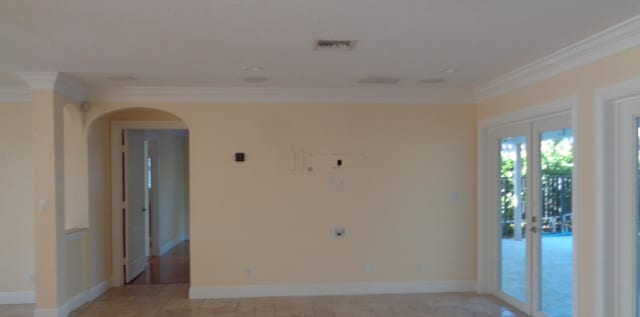 empty room featuring crown molding and french doors