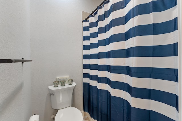 bathroom with a shower with curtain and toilet