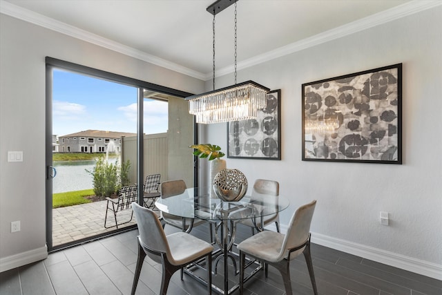 dining space featuring a chandelier, a water view, and crown molding