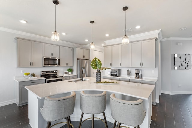 kitchen featuring decorative light fixtures, gray cabinets, sink, and appliances with stainless steel finishes