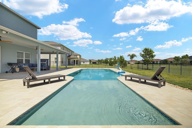 view of pool featuring ceiling fan, an outdoor living space, a patio, and a yard