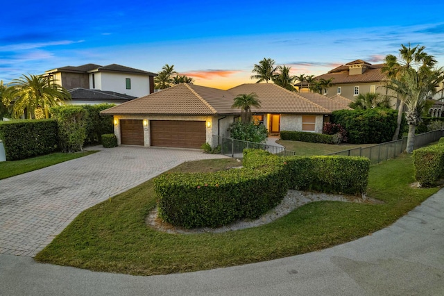 view of front of house with a garage and a lawn