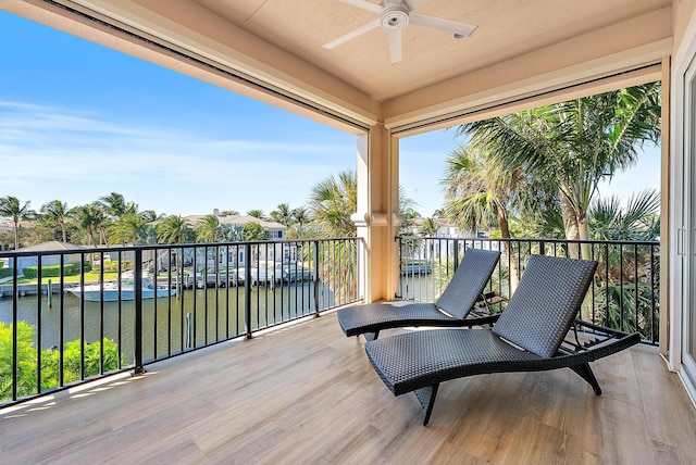 balcony with ceiling fan and a water view