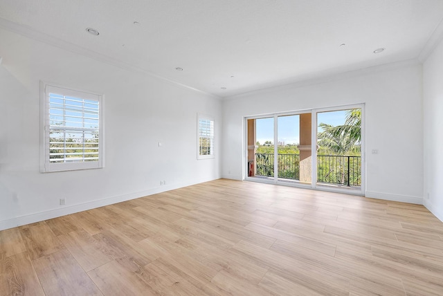 spare room with a healthy amount of sunlight, light hardwood / wood-style floors, and ornamental molding