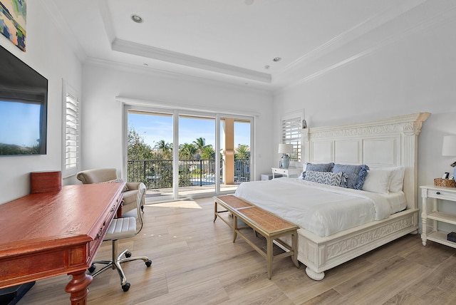 bedroom with light hardwood / wood-style floors, access to exterior, ornamental molding, and a tray ceiling