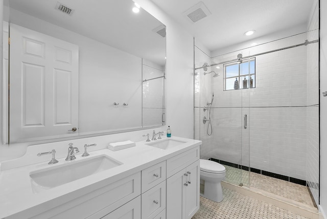 bathroom with vanity, toilet, and a shower with shower door