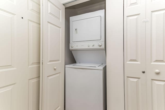 clothes washing area with stacked washer and clothes dryer