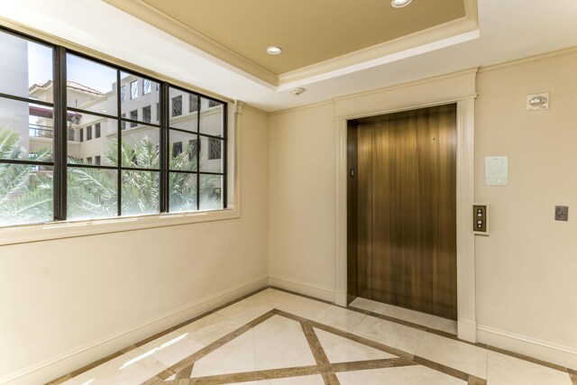 spare room featuring a tray ceiling and elevator