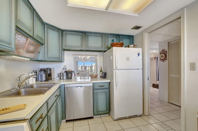 kitchen with white refrigerator, green cabinets, sink, and stainless steel dishwasher