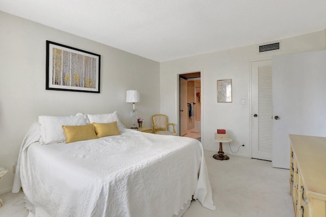 bedroom featuring light colored carpet and connected bathroom