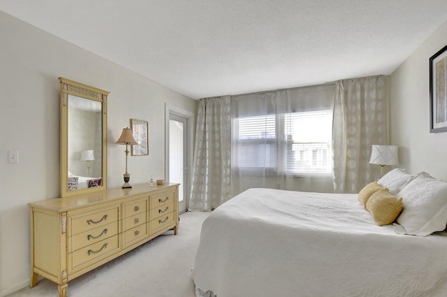 bedroom with light carpet and a textured ceiling