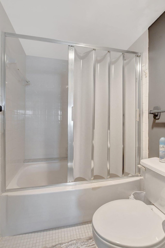 bathroom featuring enclosed tub / shower combo and toilet