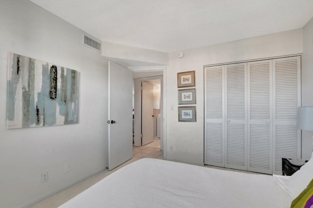 bedroom with light tile patterned floors and a closet