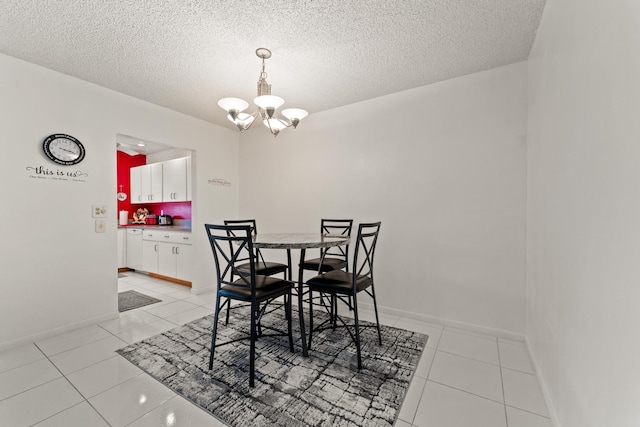 tiled dining area featuring a textured ceiling and an inviting chandelier