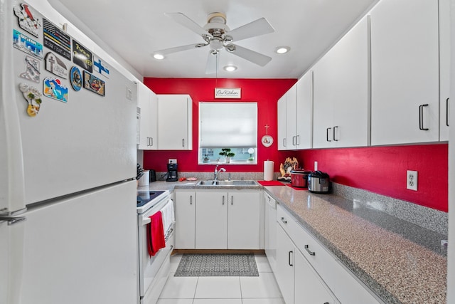 kitchen with white fridge, electric range oven, white cabinetry, and light tile patterned flooring