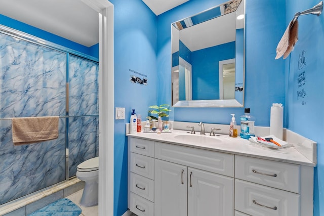 bathroom featuring a tile shower, vanity, and toilet