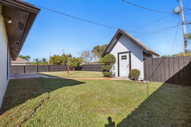 view of yard featuring an outbuilding, a patio area, and a fenced backyard