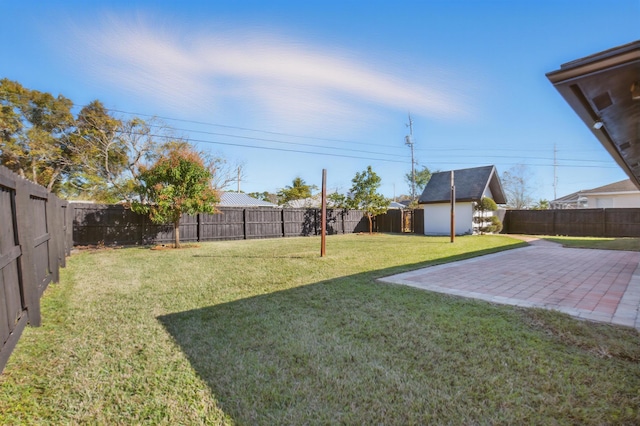 view of yard with a fenced backyard, a patio, and an outdoor structure