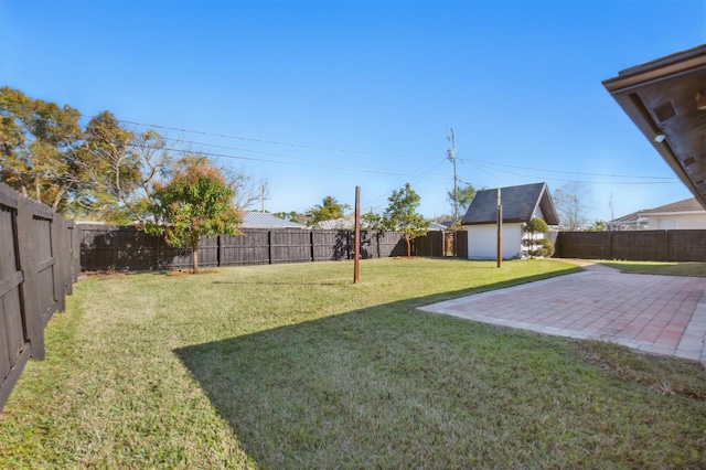 view of yard featuring a patio, an outdoor structure, and a fenced backyard