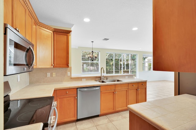 kitchen featuring tasteful backsplash, stainless steel appliances, sink, decorative light fixtures, and an inviting chandelier