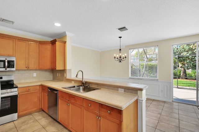 kitchen with sink, stainless steel appliances, an inviting chandelier, kitchen peninsula, and light tile patterned floors