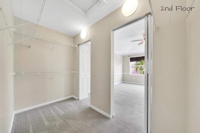 spacious closet featuring light colored carpet and ceiling fan