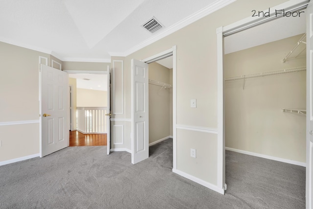 unfurnished bedroom with a closet, carpet floors, and ornamental molding