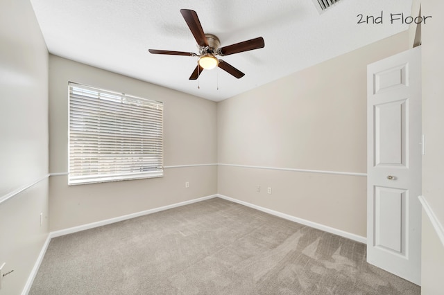 spare room featuring light colored carpet and ceiling fan