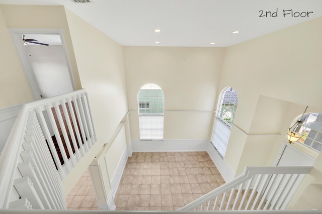 hallway with a high ceiling and light tile patterned floors