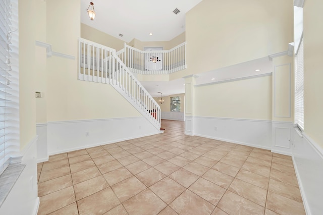 unfurnished living room with light tile patterned floors and a high ceiling