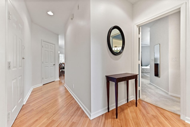 hallway with light hardwood / wood-style floors