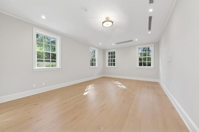 empty room featuring crown molding, light hardwood / wood-style flooring, and plenty of natural light