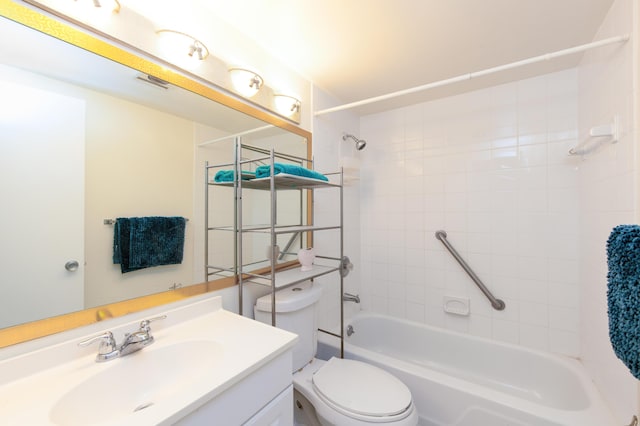 full bathroom with tiled shower / bath, vanity, and toilet