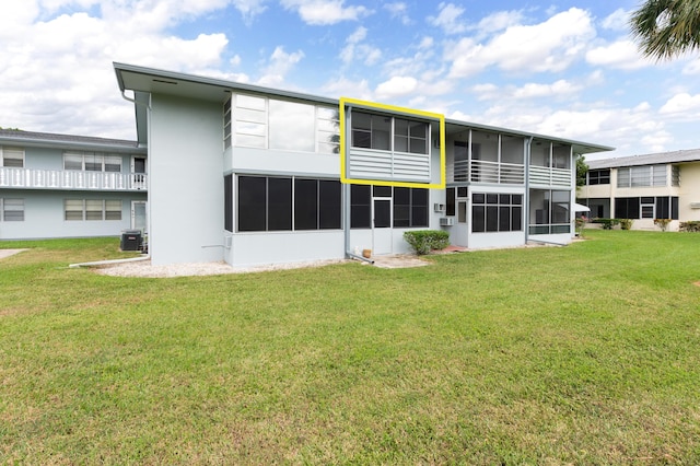 back of property featuring a yard and central air condition unit