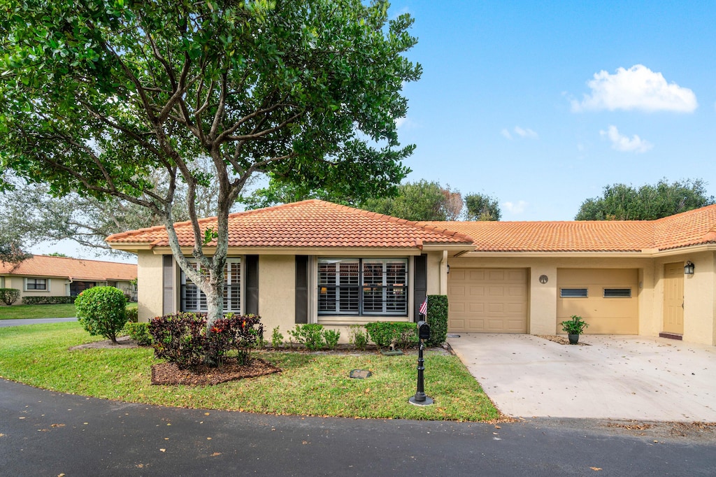 view of front of property with a front yard and a garage