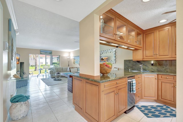 kitchen with stone countertops, light tile patterned flooring, kitchen peninsula, and sink