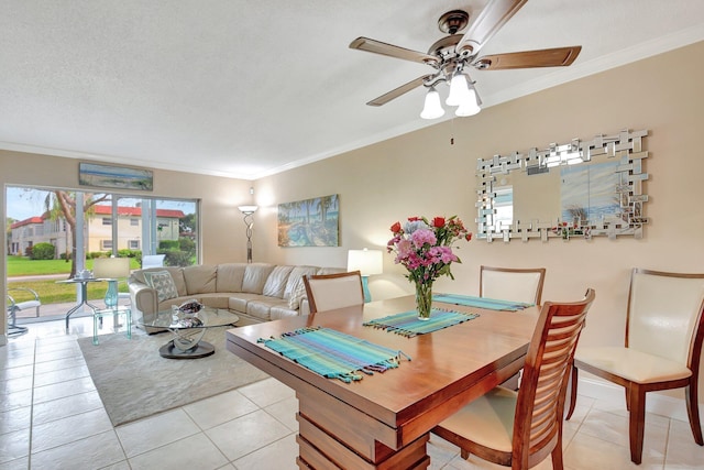 dining space featuring crown molding, light tile patterned flooring, and ceiling fan