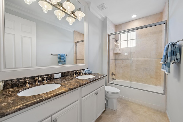 full bathroom featuring combined bath / shower with glass door, vanity, crown molding, tile patterned flooring, and toilet