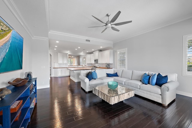 living room featuring dark hardwood / wood-style floors, ceiling fan, and crown molding