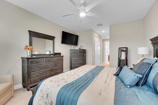 carpeted bedroom featuring ceiling fan and a textured ceiling