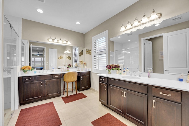 bathroom with tile patterned flooring, vanity, and a shower with door