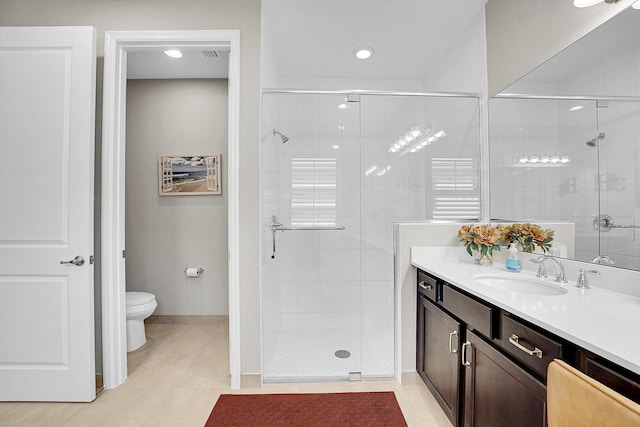 bathroom featuring tile patterned floors, vanity, toilet, and walk in shower