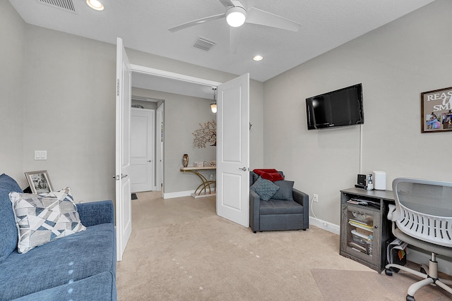 home office with light carpet, ceiling fan, and a textured ceiling