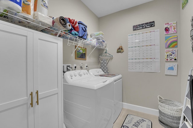 laundry area featuring cabinets, washer and dryer, and light tile patterned flooring