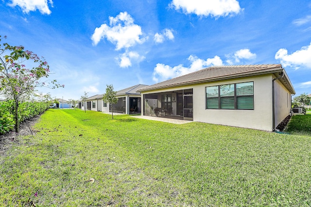 rear view of property with a lawn and a sunroom