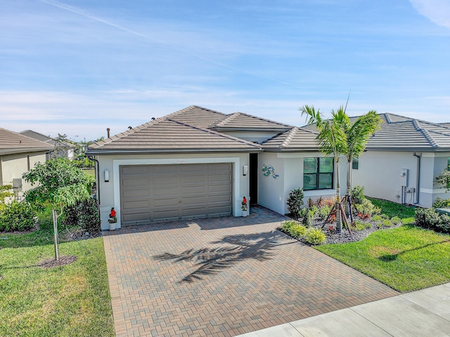 single story home featuring a garage and a front lawn