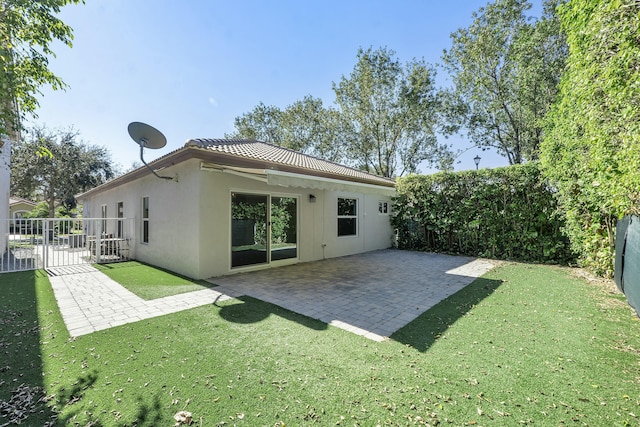 rear view of property with a lawn and a patio area