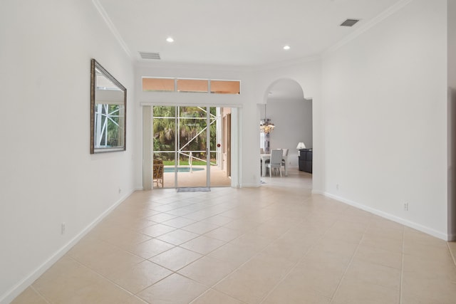 tiled spare room featuring a chandelier and crown molding