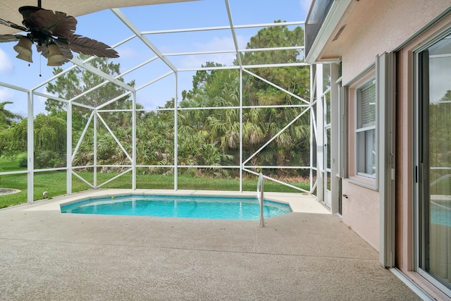 view of pool featuring glass enclosure, ceiling fan, and a patio area