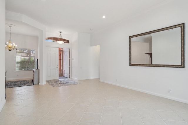 tiled foyer featuring crown molding and a chandelier